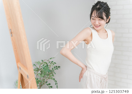 鏡でお尻をチェックして笑顔のアジア人女性（ヒップアップ） 125303749