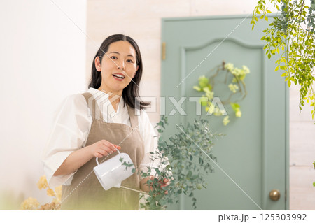 室内で植物の世話をする笑顔の大人女性｜健康的な暮らしイメージ｜ウェルビー女子｜ウェルビーイング 125303992