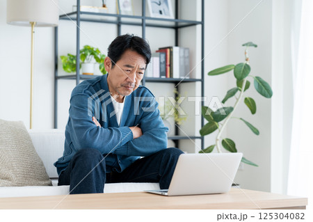 リビングでパソコンを使うミドルの男性 リビングでパソコンを使うミドルの男性 125304082