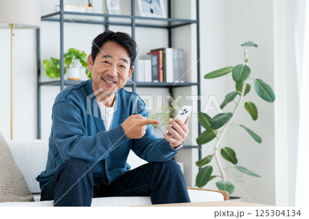 リビングでスマホを使うミドルの男性 125304134