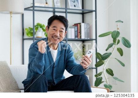 リビングでスマホを使うミドルの男性 125304135