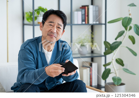 財布で悩むミドルの男性 財布で悩むミドルの男性 125304346