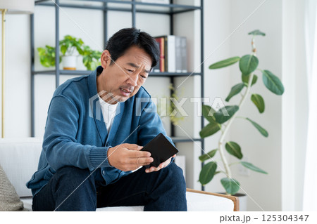 財布で悩むミドルの男性 125304347