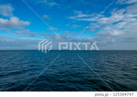 Experience the calm ocean horizon that stretches endlessly under a clear blue sky 125304747