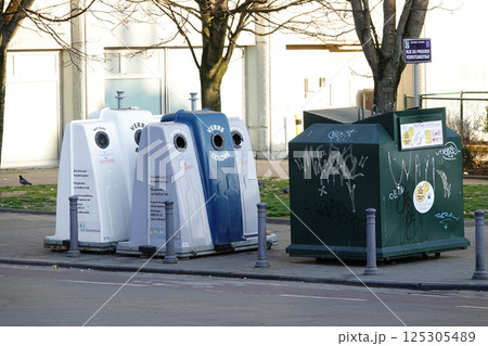 Glass recycling containers for clear, mixed, and colored glass in a city setting. 125305489