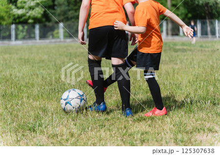 Close-up of two boys competing for soccer ball. 125307638