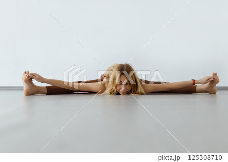 Young attractive fitness woman performing twine ,Upavista Konasana Young attractive fitness woman performing twine ,Upavista Konasana 125308710