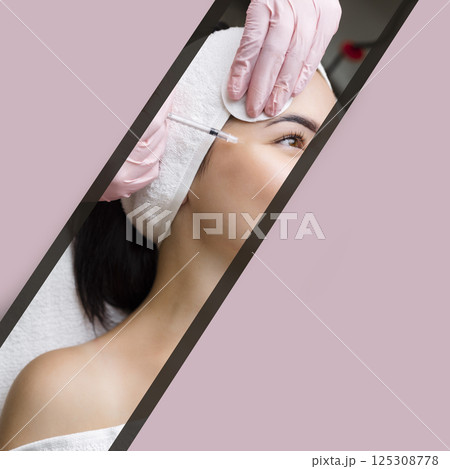 Close up of hands of young cosmetologist injecting botox in female face. She is standing and smiling. The woman is closed her eyes with relaxation 125308778