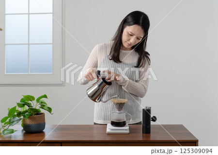 ハンドドリップでコーヒーを淹れる女性 125309094