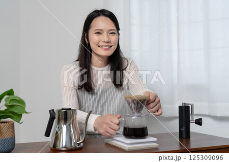 ハンドドリップでコーヒーを淹れる女性 125309096