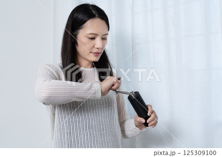 豆を挽く女性 125309100