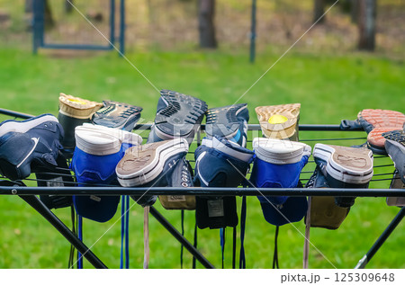 Colorful sneakers drying on metal rack outdoors in the green garden. High quality photo 125309648