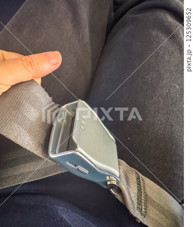 Close-up of airline seatbelt being held by passenger before takeoff. High quality photo 125309652