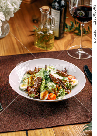Portion of salad with meat and teriyaki sauce 125309965