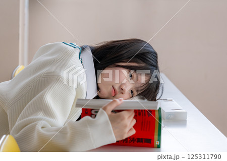 退屈そうに赤本を眺める女学生 退屈そうに赤本を眺める女学生 125311790