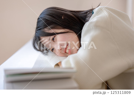 笑顔で机に伏せる学生 笑顔で机に伏せる学生 125311809