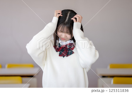 頭を抱える女子生徒 125311836