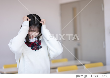 頭を抱える女子生徒 125311839