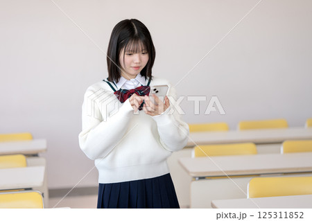 スマホを触る女子学生 125311852