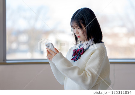 スマホでチェックする女子生徒 125311854