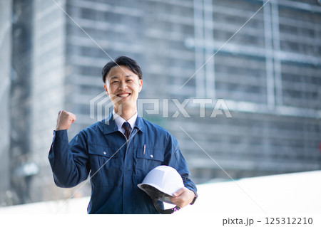 大規模な工事現場の前に立つ業者 125312210