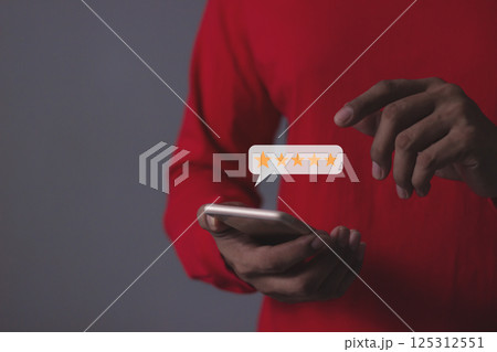 Young Man hand holding Smart Phone with five star to review and give 5 stars Young Man hand holding Smart Phone with five star to review and give 5 stars 125312551