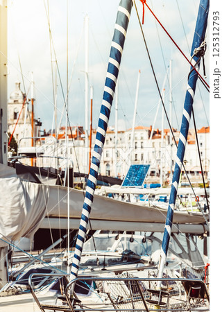 Sailboats anchored in vibrant marina on sunny day, featuring nautical details Sailboats anchored in vibrant marina on sunny day, featuring nautical details 125312793