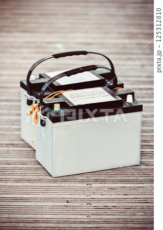 Car batteries sitting on wooden floorboards, industrial concept 125312810