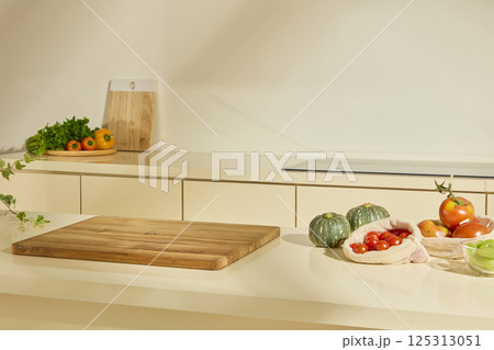 Kitchen interior with wooden cooking utensils. Kitchen cabinets hold ingredients, bags full of fresh fruits and vegetables are placed on the counter. Bright space, layout for graphic design. 125313051
