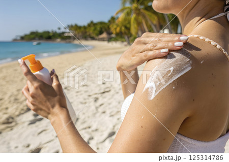 girl with sunscreen on skin enjoying beach vacation by the ocean 125314786