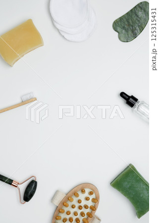 Embodying a sustainable self-care concept. Eco-friendly beauty essentials, including soap, bamboo toothbrush, marble face roller 125315431