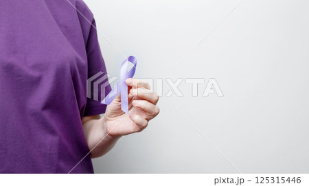 Purple ribbon held by a person in a purple shirt, symbol of support. Purple Epilepsy Awareness Day Purple ribbon held by a person in a purple shirt, symbol of support. Purple Epilepsy Awareness Day 125315446