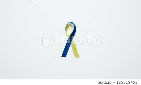 Symbolizing World Down Syndrome Day. A yellow and blue awareness ribbon 125315458