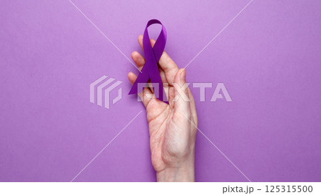 Purple ribbon held, symbol of support. Purple Epilepsy Awareness Day 125315500