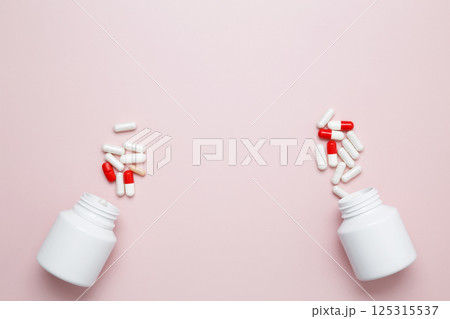 White bottles container with colorful medication capsules and tablets. Concept of healthcare and medicine 125315537
