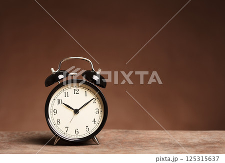 Alarm Clock on brown background Alarm Clock on brown background 125315637