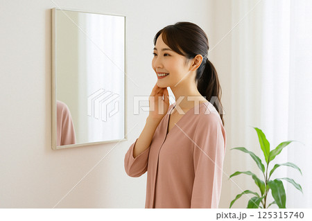 鏡で美肌を確認し満足する女性　肌質改善のイメージ 125315740