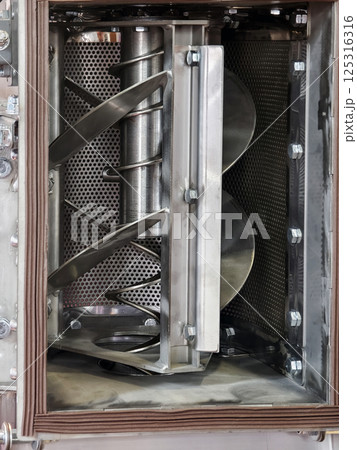 Industrial mixing machine shows rotating blades and stainless steel interior in factory environment Industrial mixing machine shows rotating blades and stainless steel interior in factory environment 125316316