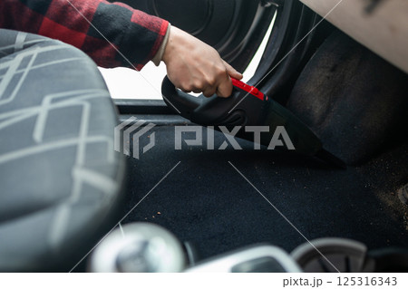 Cleaning the interior of the car with a vehicle vacuum cleaner. 125316343