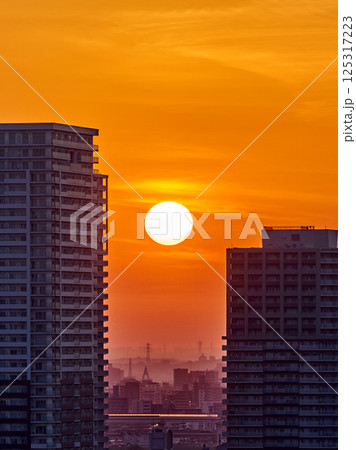 ビルの谷間に昇る朝日｜東京の夜明けと新しい一日の幕開け 125317223