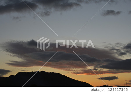 夕焼けに染まる空と電波塔 125317346