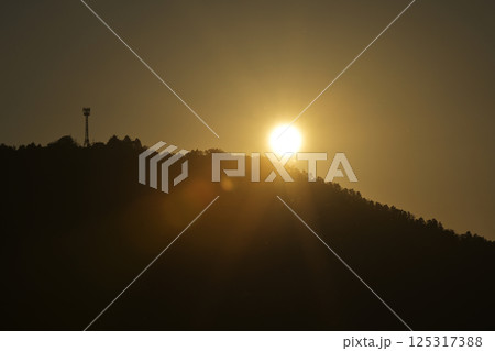 夕焼けに染まる空と電波塔 125317388