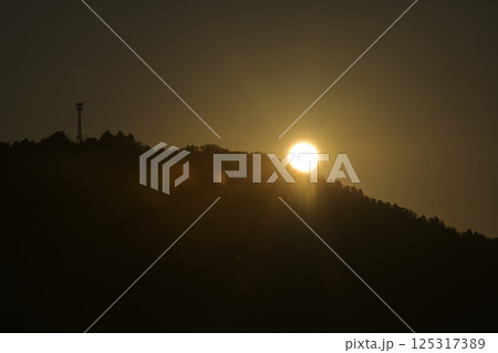 夕焼けに染まる空と電波塔 125317389