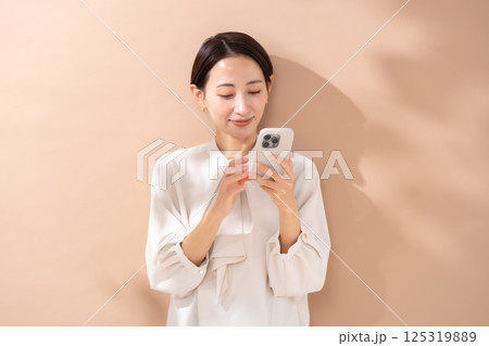 女性　ベージュバック　ポートレート　スマホ 125319889