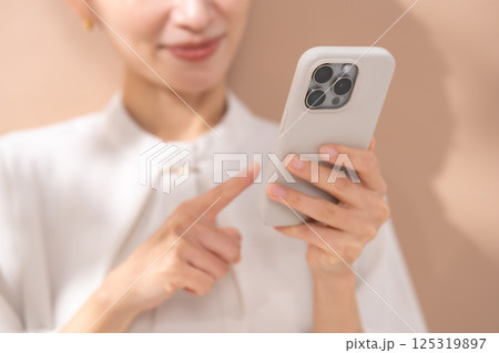 女性 ベージュバック ポートレート スマホ 女性 ベージュバック ポートレート スマホ 125319897