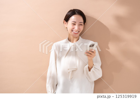 女性　ベージュバック　ポートレート　スマホ 125319919