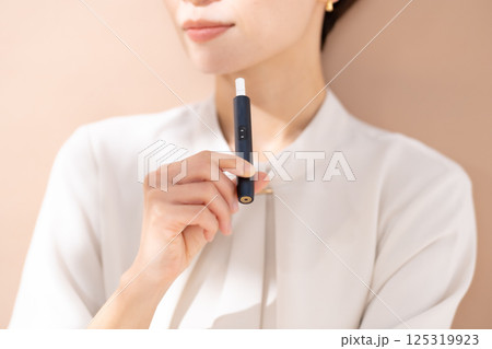 加熱式タバコを吸う女性 125319923