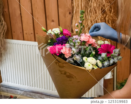 Florist arranging colorful bouquet in flower shop Florist arranging colorful bouquet in flower shop 125319983