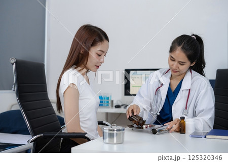 Female therapist gives medication advice to an woman patient. Female therapist gives medication advice to an woman patient. 125320346