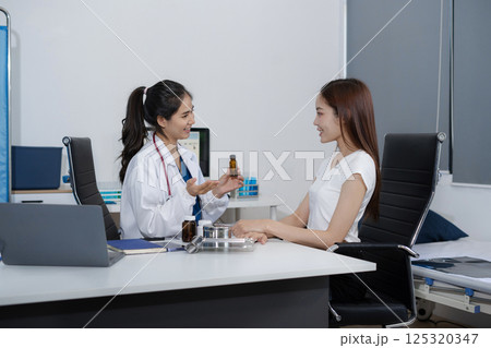 Female therapist gives medication advice to an woman patient. Female therapist gives medication advice to an woman patient. 125320347